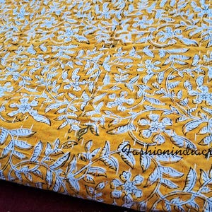 Puede incluir: Una colcha kantha amarilla y blanca con un patr&oacute;n floral. La colcha est&aacute; hecha de algod&oacute;n y est&aacute; cosida a mano. La colcha es perfecta para a&ntilde;adir un toque de estilo bohemio a tu hogar.