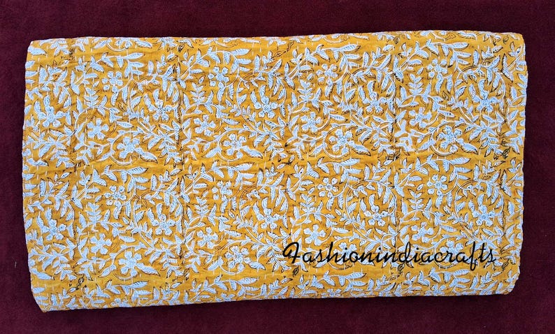 Puede incluir: Una colcha kantha amarilla con un patr&oacute;n floral blanco. La colcha est&aacute; hecha de algod&oacute;n y est&aacute; cosida a mano. La colcha mide aproximadamente 152 cm por 229 cm. La colcha es perfecta para agregar un toque de calidez y estilo a cualquier habitaci&oacute;n.