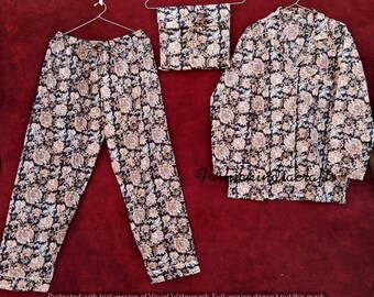 May include: A black and beige patterned pajama set with a long-sleeved top and pants. The top has a collar and button closure. The fabric has a floral design.