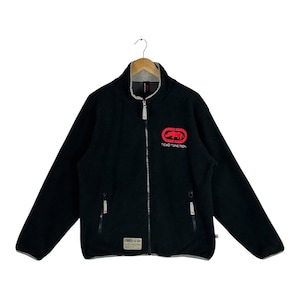 May include: A black fleece jacket featuring a high collar, a full-length front zipper, and long sleeves. The chest displays a red rhino logo with the text Ecko Function. It includes two zippered side pockets and a small rectangular brand patch.