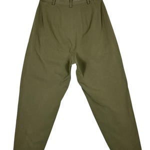 Puede incluir: Pantalones verde oliva con cintura alta y corte relajado. Los pantalones tienen trabillas y cierre de bot&oacute;n. La tela parece ser un material ligero, adecuado para ropa informal. Los pantalones est&aacute;n colocados planos sobre un fondo blanco.