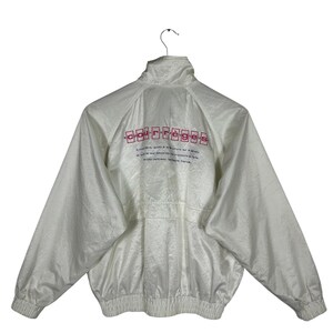 May include: White nylon jacket with a high collar and elastic cuffs. The back of the jacket features the word "courr&egrave;ges" in red block letters above additional text. The jacket has a zipper closure and a gathered waist.
