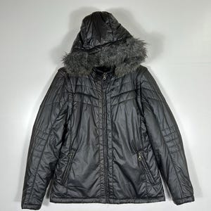 May include: Black quilted jacket with a hood trimmed with faux fur. The jacket has a zipper closure, two front pockets, and a quilted design. A winter coat for cold weather.
