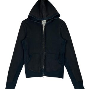 以下が含まれることがあります： シルバーのジッパーと2つのフロントポケットが付いた、黒色のフード付きジップアップスウェットシャツ。スウェットシャツは、ドローストリングフードとリブ編みの袖口と裾を備えています。「w+h」のブランド名がタグに表示されています。