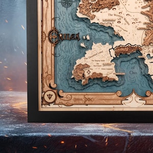 May include: A detailed wooden map with a black frame. The map features a layered design with blue water and tan landmasses. Text includes "CRILEA", "The Deserted Land", and "Gulf of Oro". The map is a decorative piece.