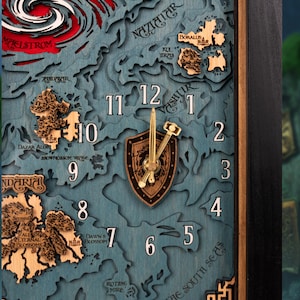 May include: A wooden wall clock with a map design. The clock face is blue with a layered topographic effect. The clock hands are gold-colored, and the numbers are white. The clock features a shield-shaped center with a hammer and sword design.