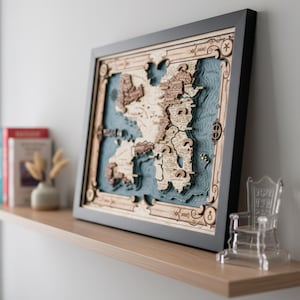 May include: A framed, multi-layered wooden map featuring intricate topographical details and landmasses in light and dark wood tones set against a deep blue textured ocean background. The map includes engraved text labels and decorative border elements.