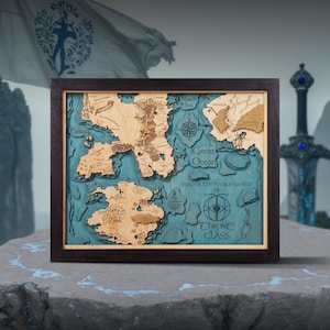 Op de afbeelding: Een houten kaart met een donkerbruine lijst. De kaart heeft een gedetailleerd, gelaagd ontwerp met lichtbruine landmassa's en een blauwe oceaan. Tekst op de kaart is onder meer "Great Ocean" en "Throne Class". Een decoratief zwaard staat op de achtergrond.