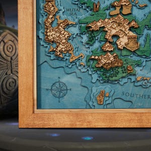 以下が含まれることがあります： 航海をテーマにした、フレーム入りの積層木製地図。 地図には、青い海、緑とタン色の陸地、羅針盤が描かれています。 フレームは明るい茶色の木材で作られています。 地図には「WUTAI SEA」と「SOUTHERN」の文字が含まれています。