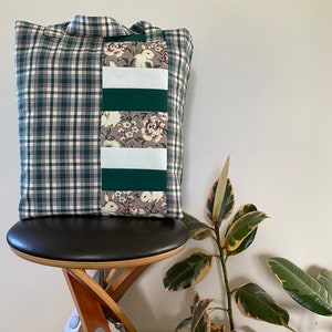 May include: A green and white checked tote bag with a patchwork design on one side. The patchwork includes white fabric, green fabric, and a floral print fabric with white bunnies.