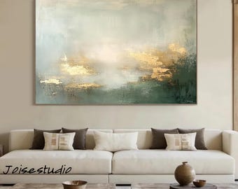 May include: Abstract landscape painting with a gold, green, and white color palette. The artwork features textured brushstrokes and a rectangular shape. The painting is displayed above a white sofa in a living room setting.
