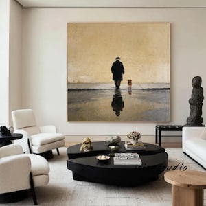 May include: Large framed oil painting depicting a person walking a dog in the rain. The artwork features a muted color palette with a person in a black coat and hat, and a small brown dog. The person's reflection is visible in the water.
