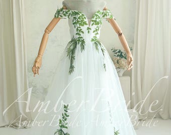 Bruidsjurk met groene bladeren en borduursels, off-shoulder, boho A-lijn model, tule.