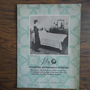 Op de afbeelding: Vintage advertentie voor "fily" gehaakte sprei en nieuwigheden. De afbeelding toont een zwart-wit slaapkamerscène met een vrouw bij een bed. De rand heeft een lichtgroen gehaakt patroon. Tekst bevat "CROCHETED BEDSPREADS & NOVELTIES".