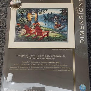 Puede incluir: Un kit de punto de cruz contado Dimensions The Gold Collection titulado Calma del crepúsculo de Darrell Bush. El paquete muestra un paisaje con dos sillas rojas junto a un lago al atardecer, mide 40,6 cm por 27,9 cm e incluye un organizador de hilos.