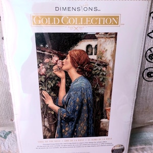 Può includere: Un kit a punto croce contato Dimensions Gold Collection intitolato "Soul of the Rose". L'immagine mostra una donna che annusa una rosa. Il kit misura 27,9 cm x 40,6 cm.