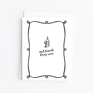 May include: A white greeting card with a black border and the text "real friends bring wine." The card features a simple illustration of a wine bottle and a glass. The card is paired with a white envelope.