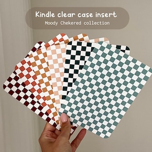 Könnte beinhalten: Ein Satz von acht Schachbrett-Muster-Einsätzen für ein klares Kindle-Etui. Die Muster umfassen Rot, Braun, Pfirsich, Schwarz und Grün.
