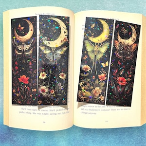 May include: Three iridescent bookmarks with a black background and a crescent moon, stars, and butterflies. The butterflies are a monarch, a luna moth, and a swallowtail. The bookmarks are decorated with glitter.