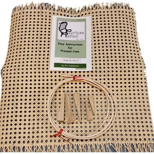 May include: A kit for pressed cane chair seats. The kit includes a sheet of woven cane, wooden wedges, a wooden hoop, and a printed instruction sheet. The instruction sheet reads "Easy Instructions for Pressed Cane" and "Please Be Seated".