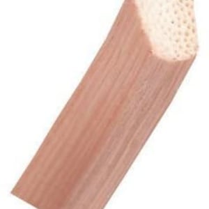 May include: A close-up of a natural wood dowel rod with a rounded, slightly pointed end. The dowel is smooth and has a light brown color.