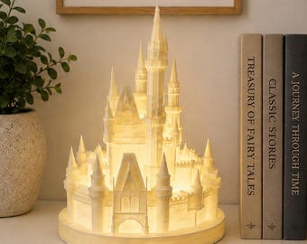 May include: A white, illuminated castle lamp featuring multiple towers, spires, and a central arched entrance. The structure is crafted with a textured, marble-like finish and sits on a circular base, emitting a warm, soft glow from within.