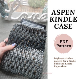 Puede incluir: Funda para Kindle tejida a crochet en un esquema de color gris y blanco con una textura moteada. La funda está hecha con un punto básico y es adecuada tanto para el Kindle Basic como para el Kindle Paperwhite. La imagen incluye el texto "ASPEN KINDLE CASE" y "PDF Pattern".