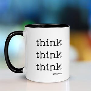 May include: White ceramic mug with a black rim and handle. The mug has the text "think think think" printed on it in black, with the attribution "W.T. Pooh" below the text.