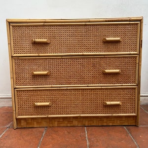 Op de afbeelding: Een dressoir met drie lades gemaakt van geweven bamboe met natuurlijke houttinten. Het dressoir heeft drie lades met eenvoudige houten handgrepen.