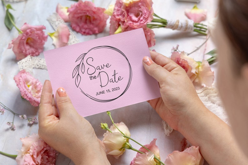 May include: A pink save the date card with a black circle and the text "Save the Date" and "JUNE 15, 2023".