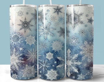Könnte beinhalten: Drei Edelstahlbecher mit winterlichem Design. Die Becher haben einen Aquarellhintergrund mit weißen Schneeflocken in verschiedenen Größen und filigranen Designs. Der Hintergrund verläuft von einem hellen Blau zu einem dunkleren Blau.