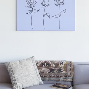 May include: A light purple canvas print with a black line drawing of three roses.