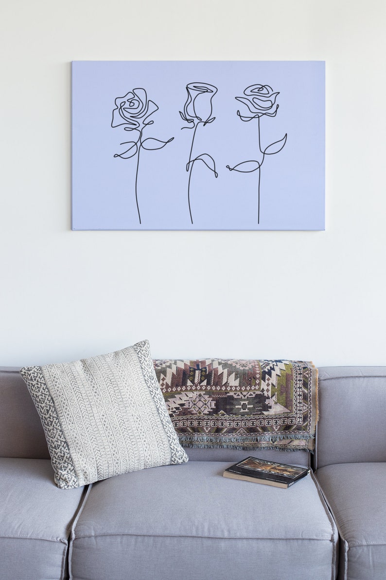 May include: A light purple canvas print with a black line drawing of three roses.