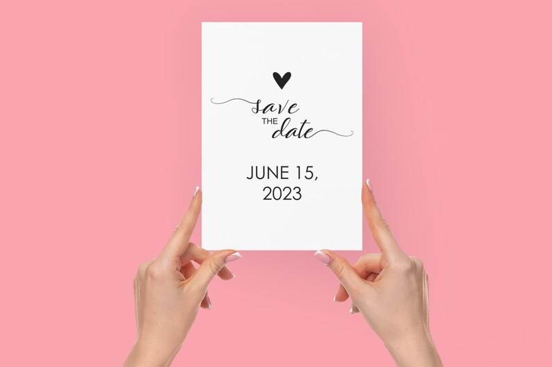 May include: A white card with black text that reads "Save the date" with a small black heart above the text. The date June 15, 2023 is printed below the text.