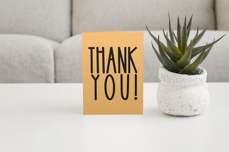 May include: A thank you card with the words "THANK YOU!" in black lettering on a light orange background.