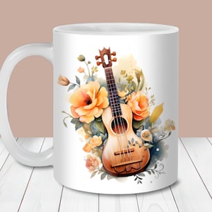 Könnte beinhalten: Weiße Keramiktasse mit einer Aquarellillustration einer Ukulele und gelben Rosen. Die Ukulele ist hellbraun mit schwarzen Saiten, und die Blumen haben orange und gelbe Blütenblätter. Das Design ist vor einem weichen, verschwommenen Hintergrund.