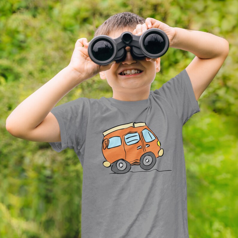 May include: A gray t-shirt with a cartoon illustration of an orange camper van with a white roof and yellow windows.