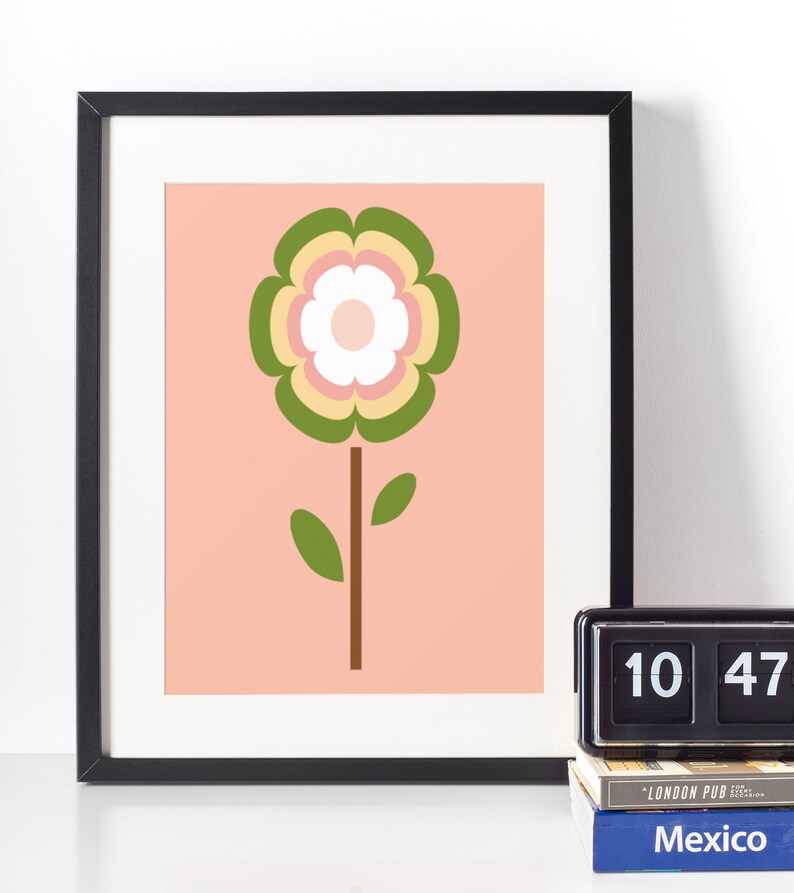 May include: A framed print of a stylised flower with green, yellow, pink and white petals on a peach background.