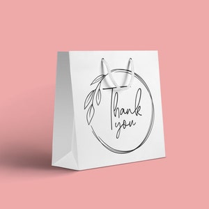 May include: White paper gift bag with a black and white circle design featuring a floral motif and the text "Thank you".