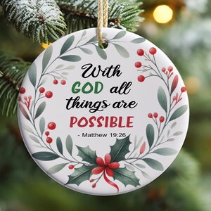 May include: White round Christmas bauble with a green wreath design and red berries. The bauble has the text "With GOD all things are POSSIBLE - Matthew 19:26".