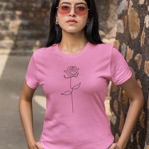 May include: A pink t-shirt with a simple line drawing of a rose on the front.