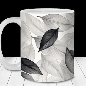 May include: White ceramic mug with a black and white leaf pattern. The leaves are stylized and have a watercolor effect.