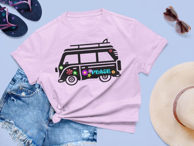 May include: A pink t-shirt with a black silhouette of a vintage van with the word "PEACE" on the side. The van has a surfboard on top and flowers on the side.
