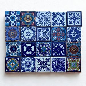 May include: A set of twenty square ceramic tiles featuring detailed blue and white patterns. The designs include floral, geometric, and abstract motifs. The tiles are arranged in a rectangular grid, showcasing a variety of decorative styles.