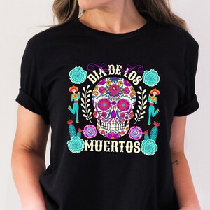May include: Black t-shirt with a colorful sugar skull design and the text "Dia de los Muertos".
