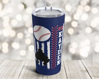 May include: A blue and white stainless steel tumbler with a baseball graphic, a silhouette of a baseball player, and the text "20 KAYDEN".