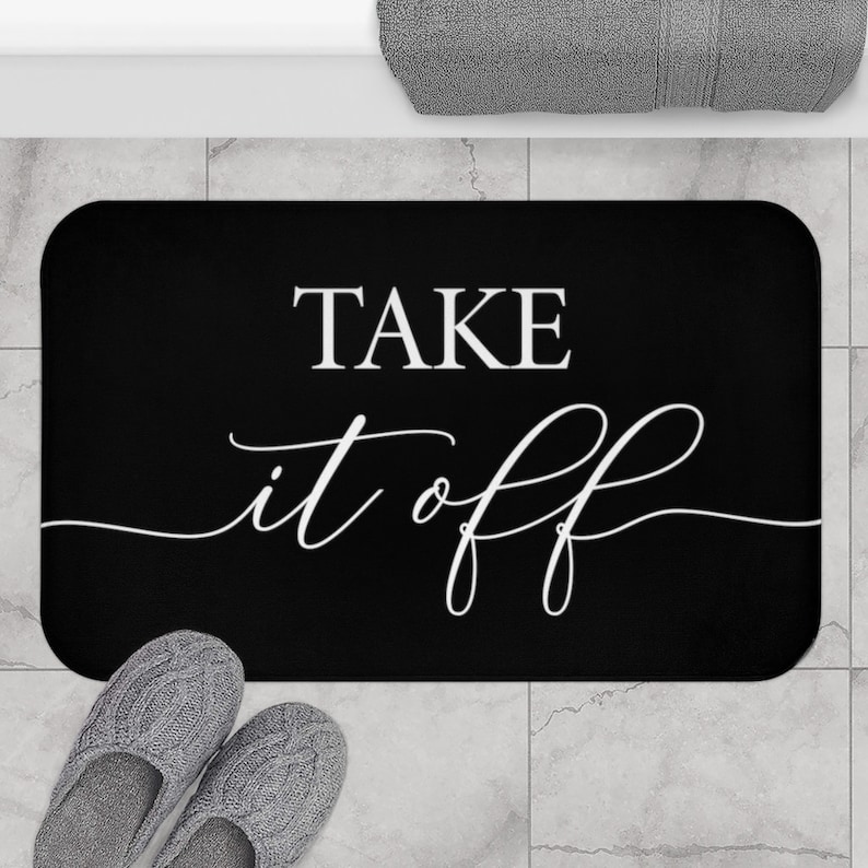 May include: Black bath mat with white text that reads "TAKE it off".