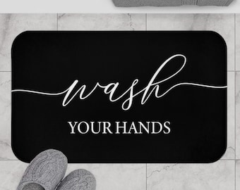 May include: Black bath mat with white text that reads "Wash Your Hands".