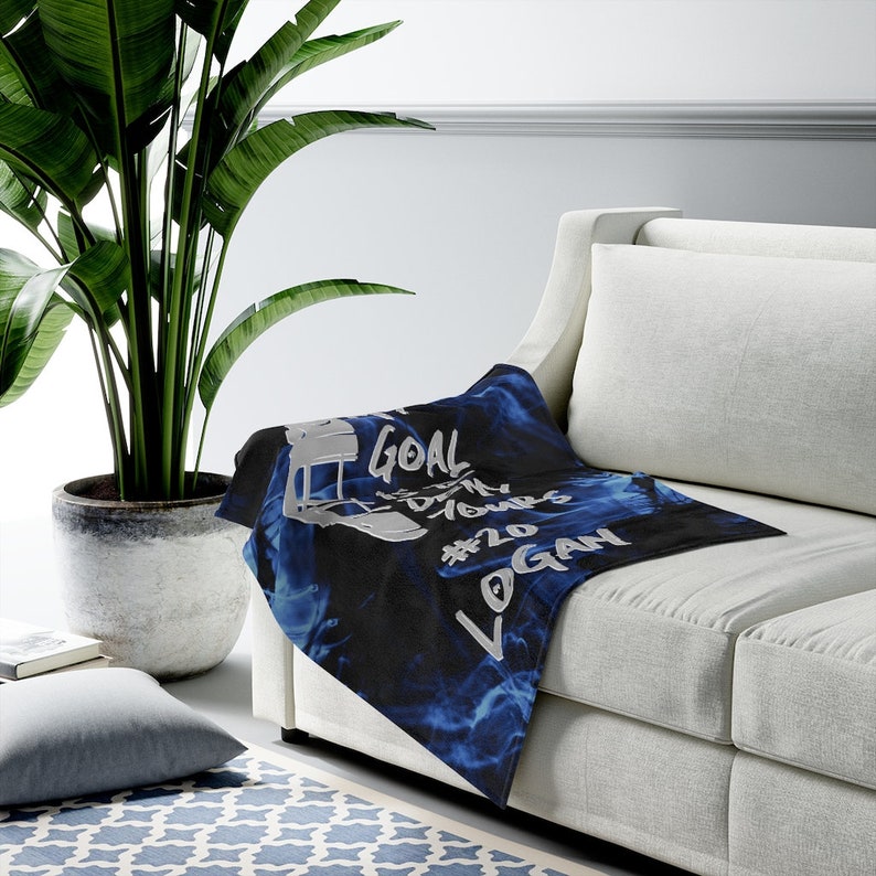 May include: A black and blue fleece throw blanket with a white football helmet graphic and the text "GOAL IS MY DREAMS #20 LOGAN".