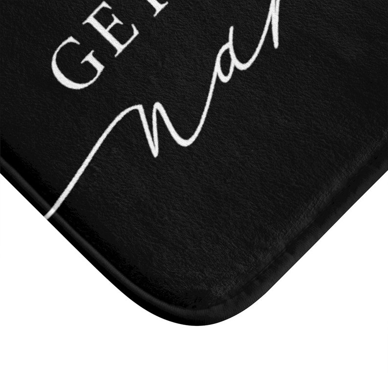 May include: Black bath mat with white text that reads "Get in, madame".